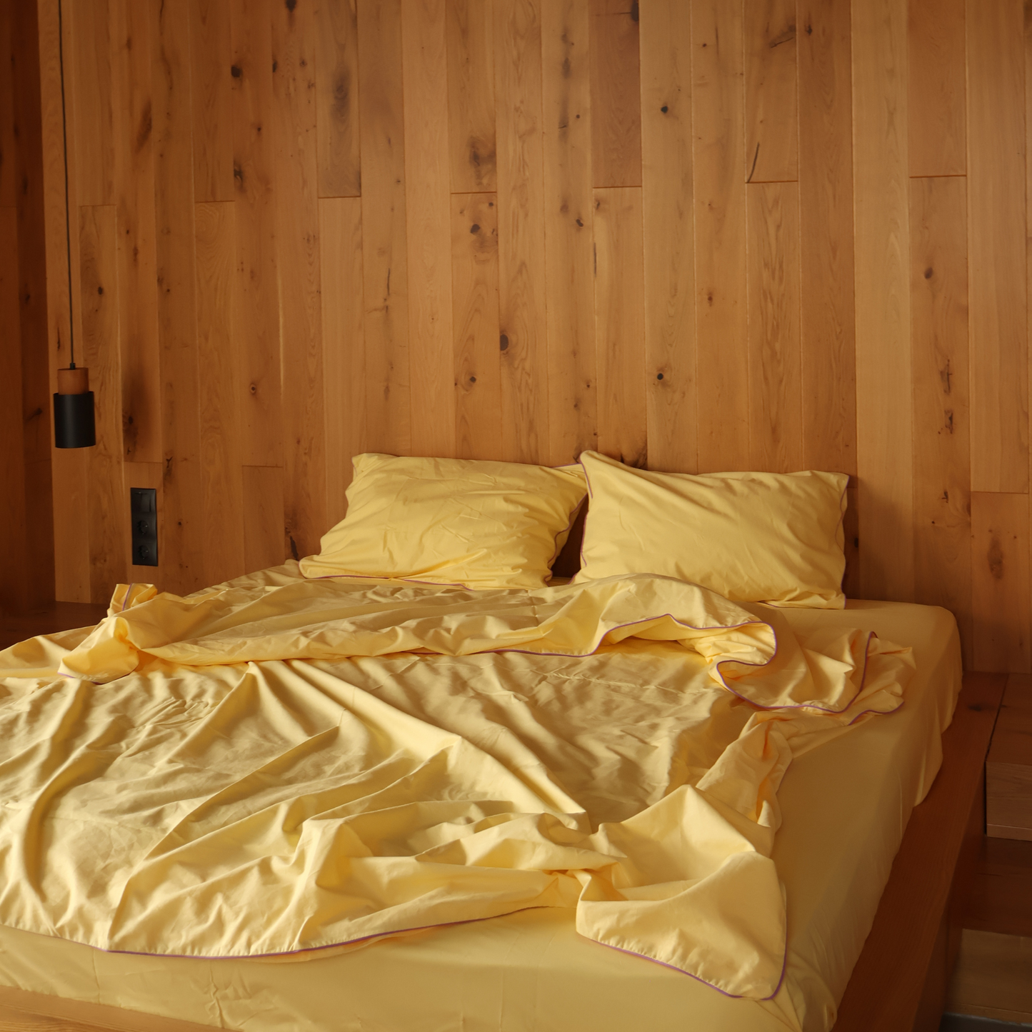 Complete yellow bedding collection by BUTTIA including a soft bed sheet, pillowcases and a duvet cover with lavender piping.
