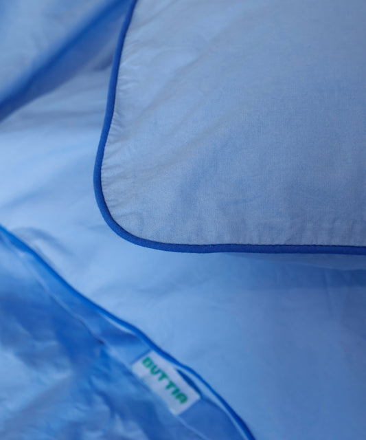 Close-up of a blue garment bag with 'BUTTIA' branding.