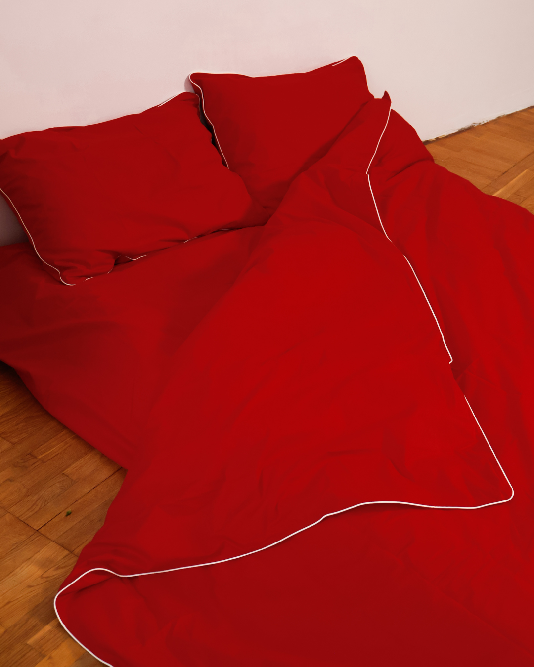 Red cotton duvet cover and pillowcases set with focus on natural fabric texture.