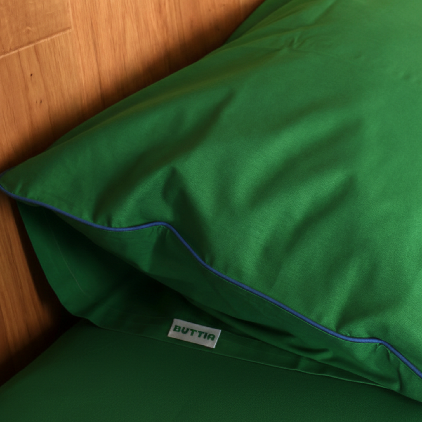 BUTTIA green bed pillowcase with stylish blue edge detail made of natural fabric.