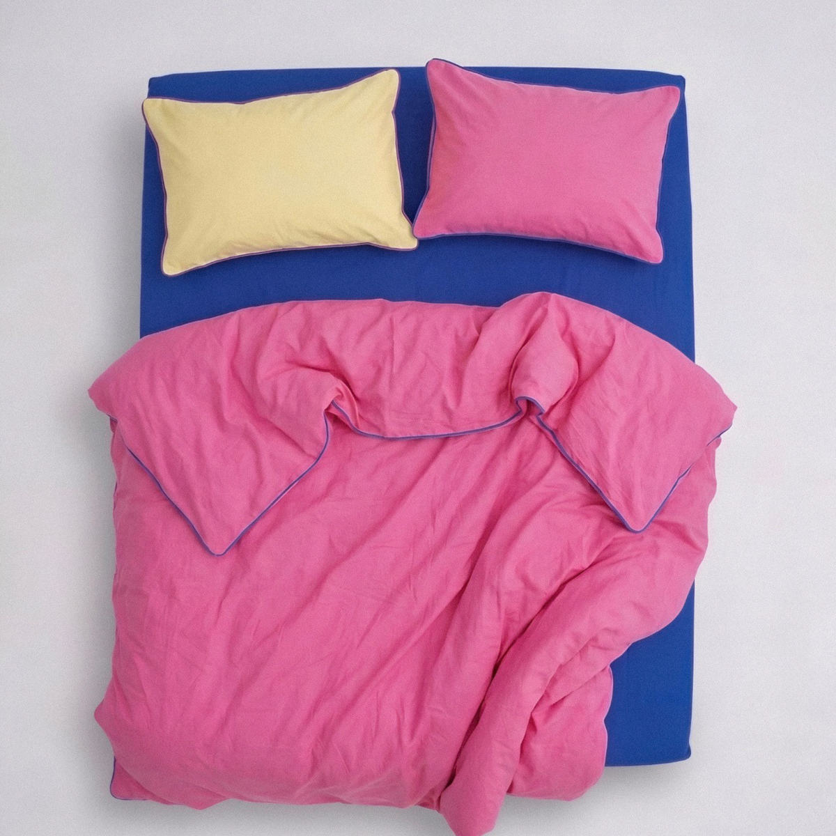 Pink bedding set with blue mattress on a white background
