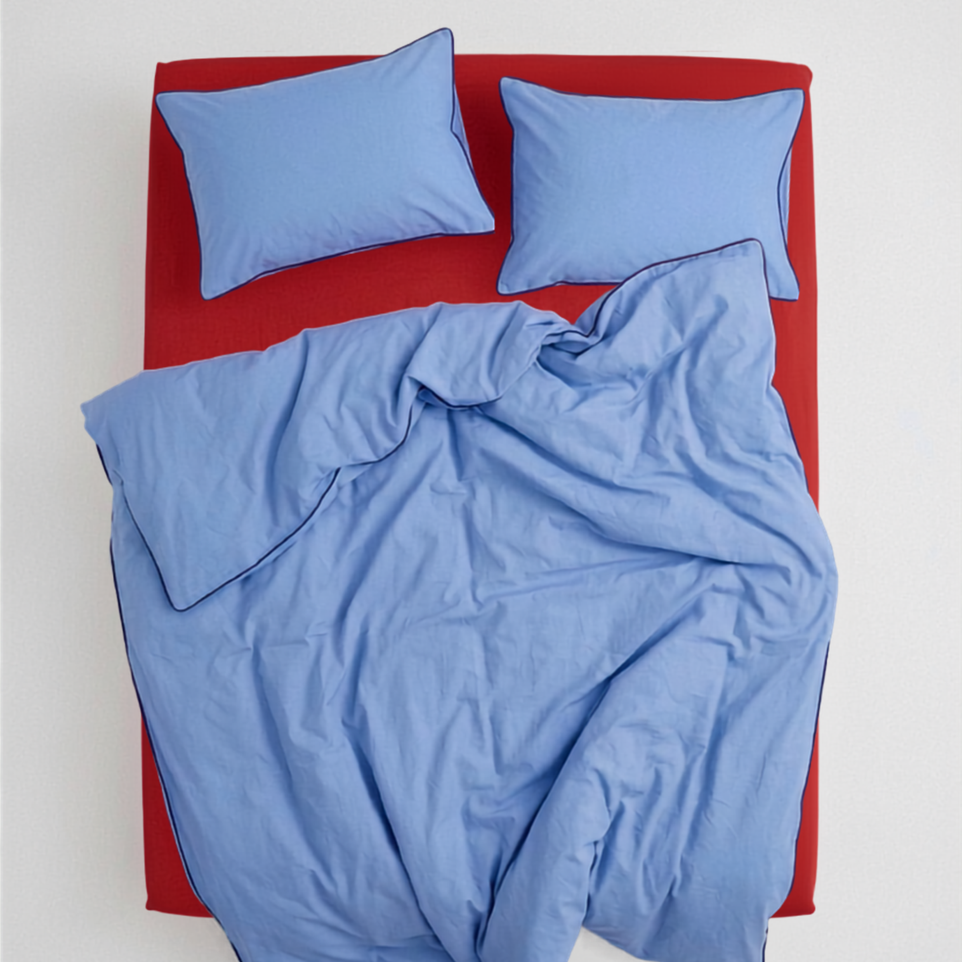 Light blue and red bedding set with two light blue pillowcases, view from above. BORDERLINE Palette 07 by BUTTIA, handmade cotton bedding with navy accent piping.