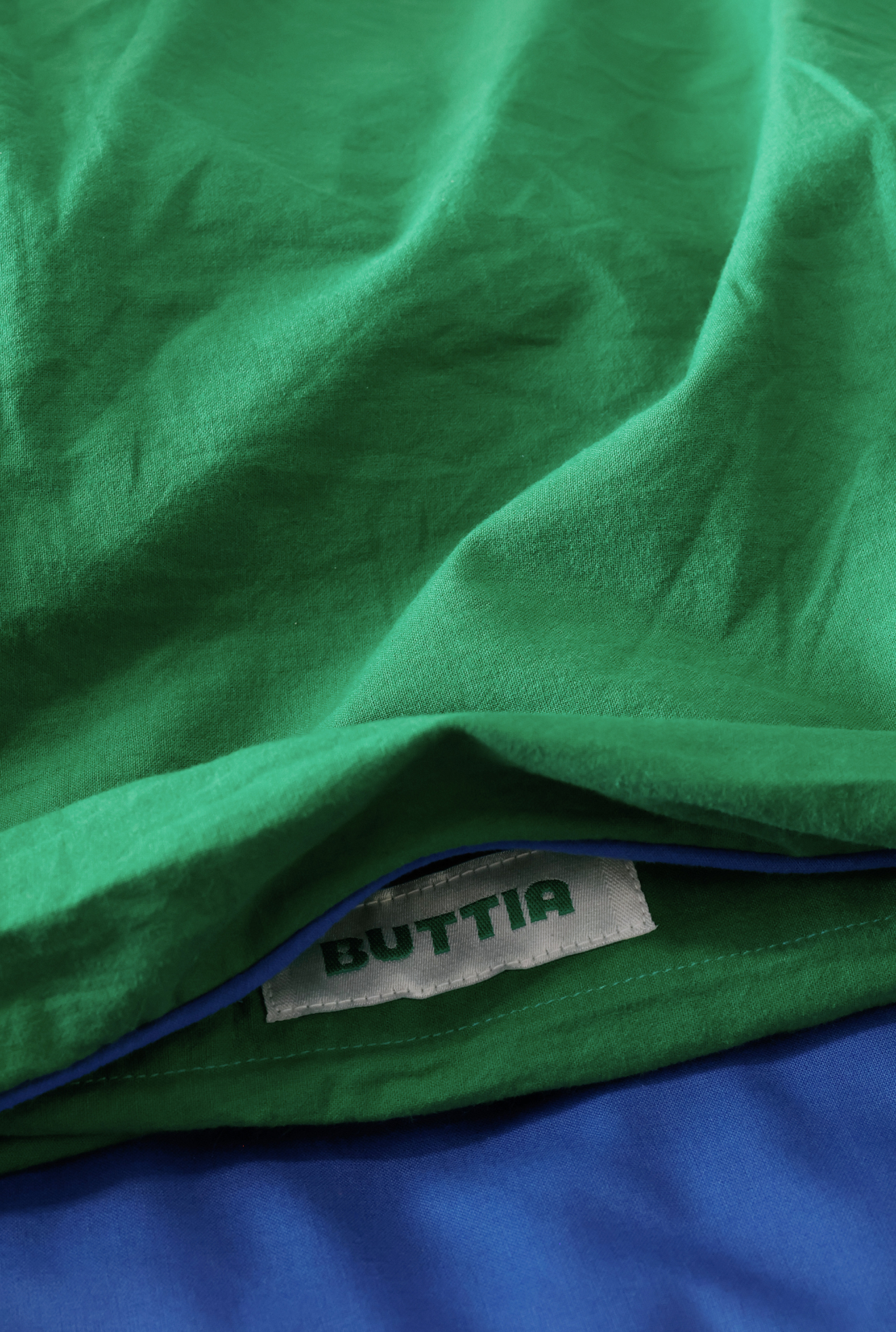 Close-up of green fabric with a 'BUTTIA' label.