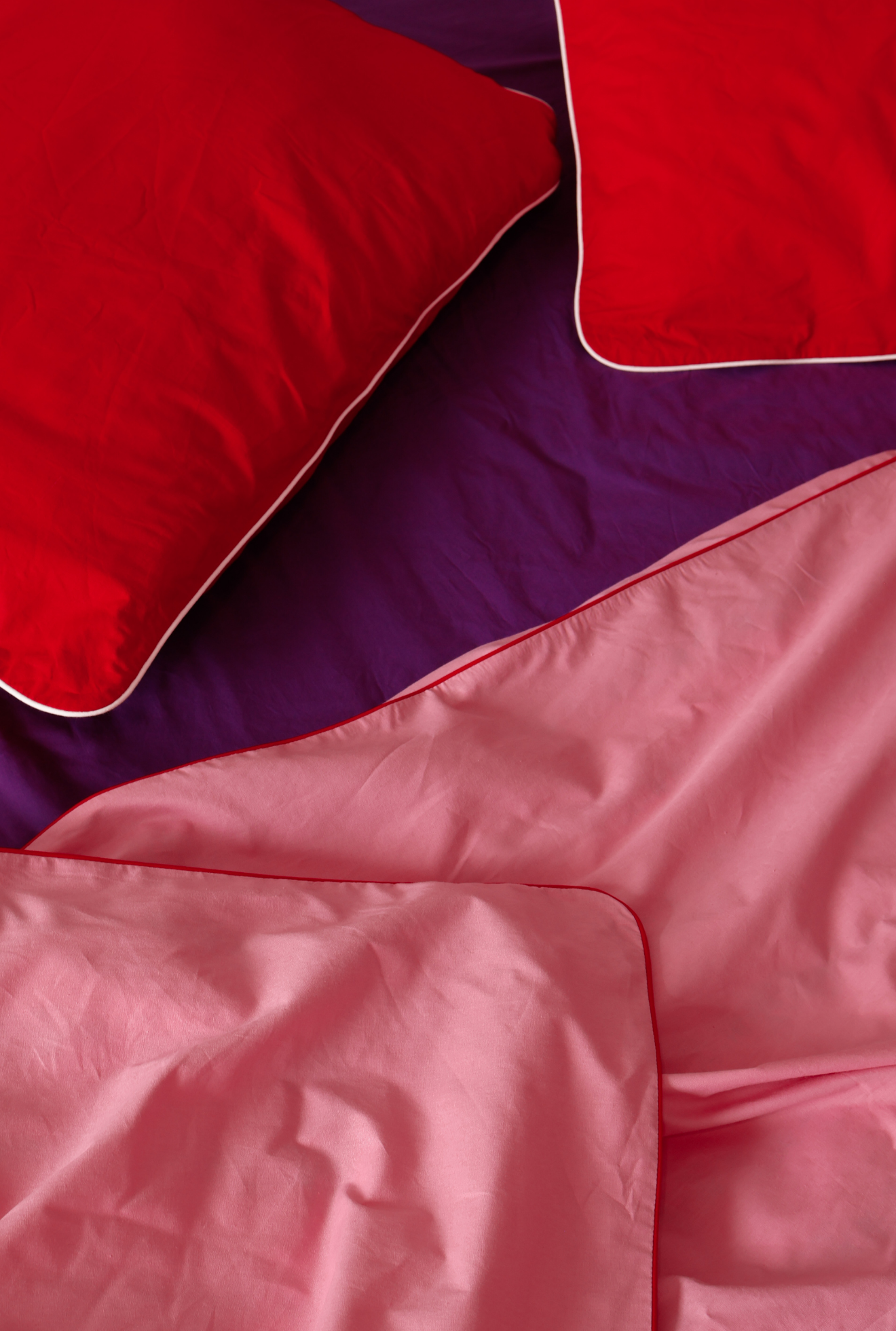 Close-up of red and pink bedding on a purple background