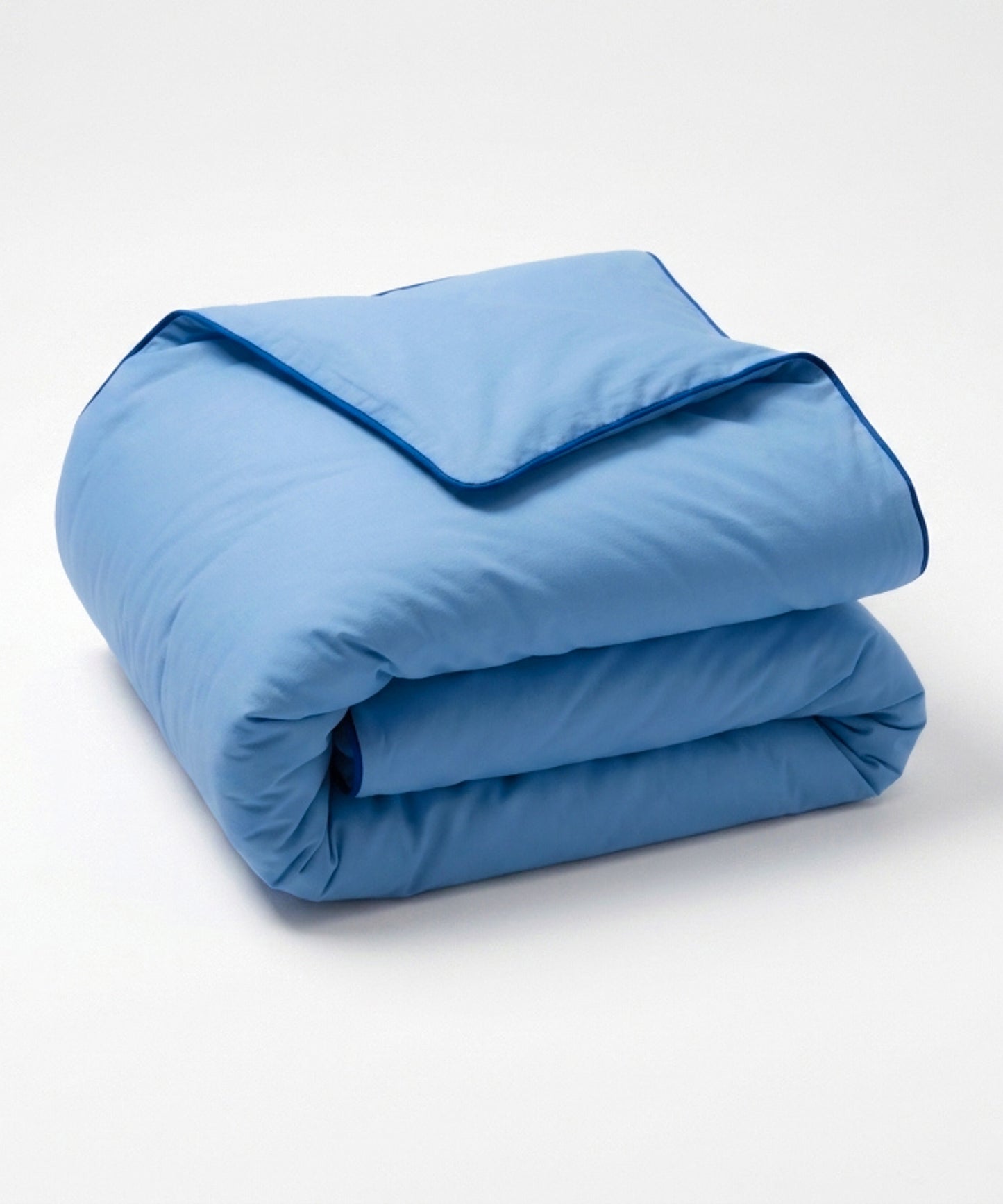 A folded light blue comforter or duvet with matching piping, photographed on a clean white studio background.