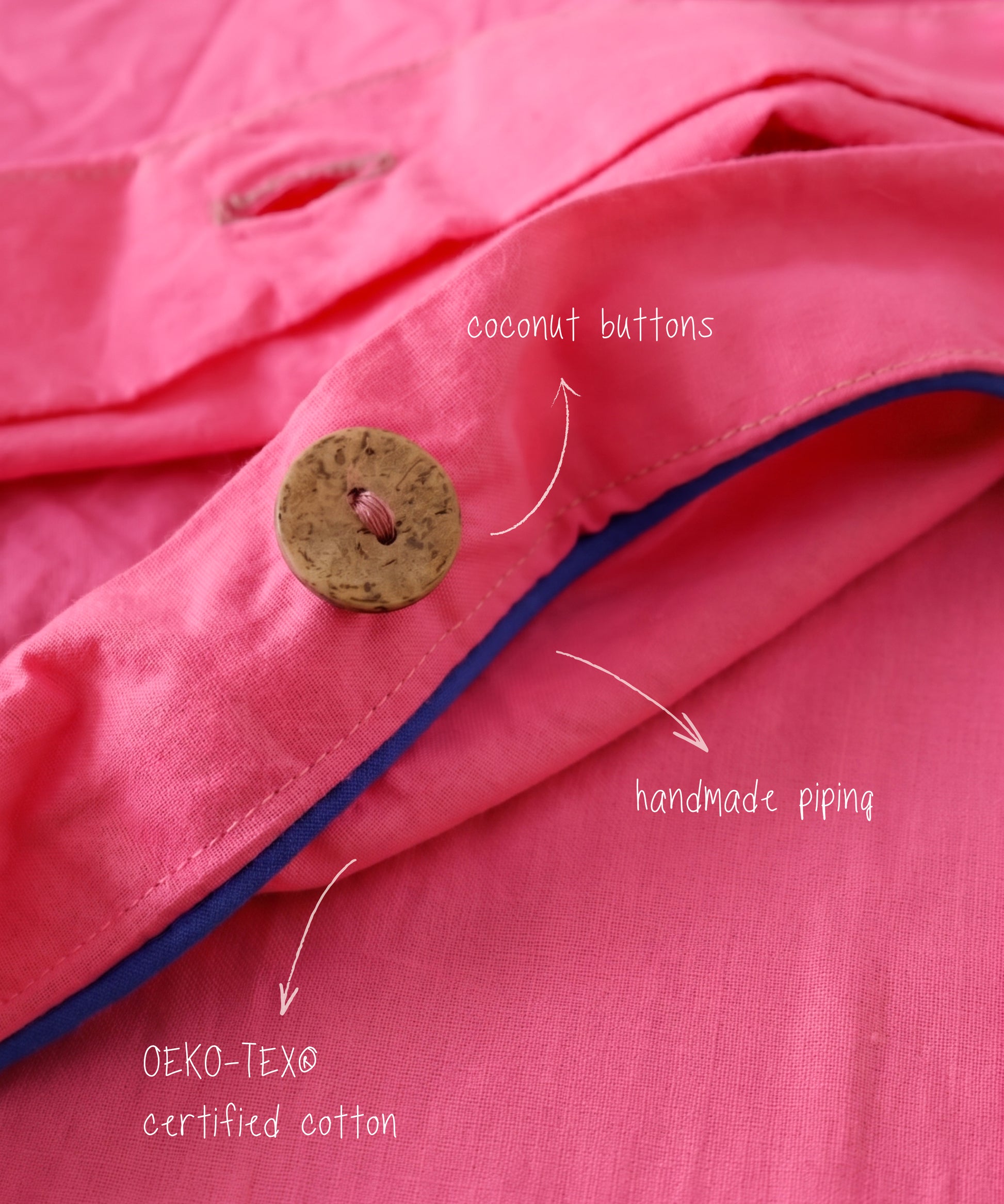 Close-up of pink fabric with coconut buttons and handmade piping.