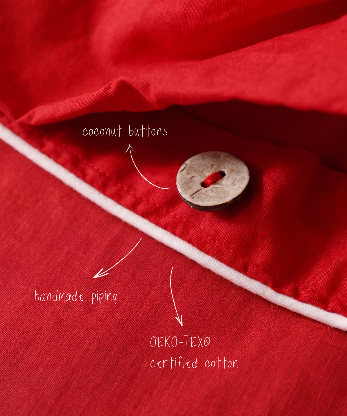 Red fabric with a coconut button, white piping, and text indicating 'coconut buttons', 'handmade piping', and 'OEKO-TEX certified cotton'.