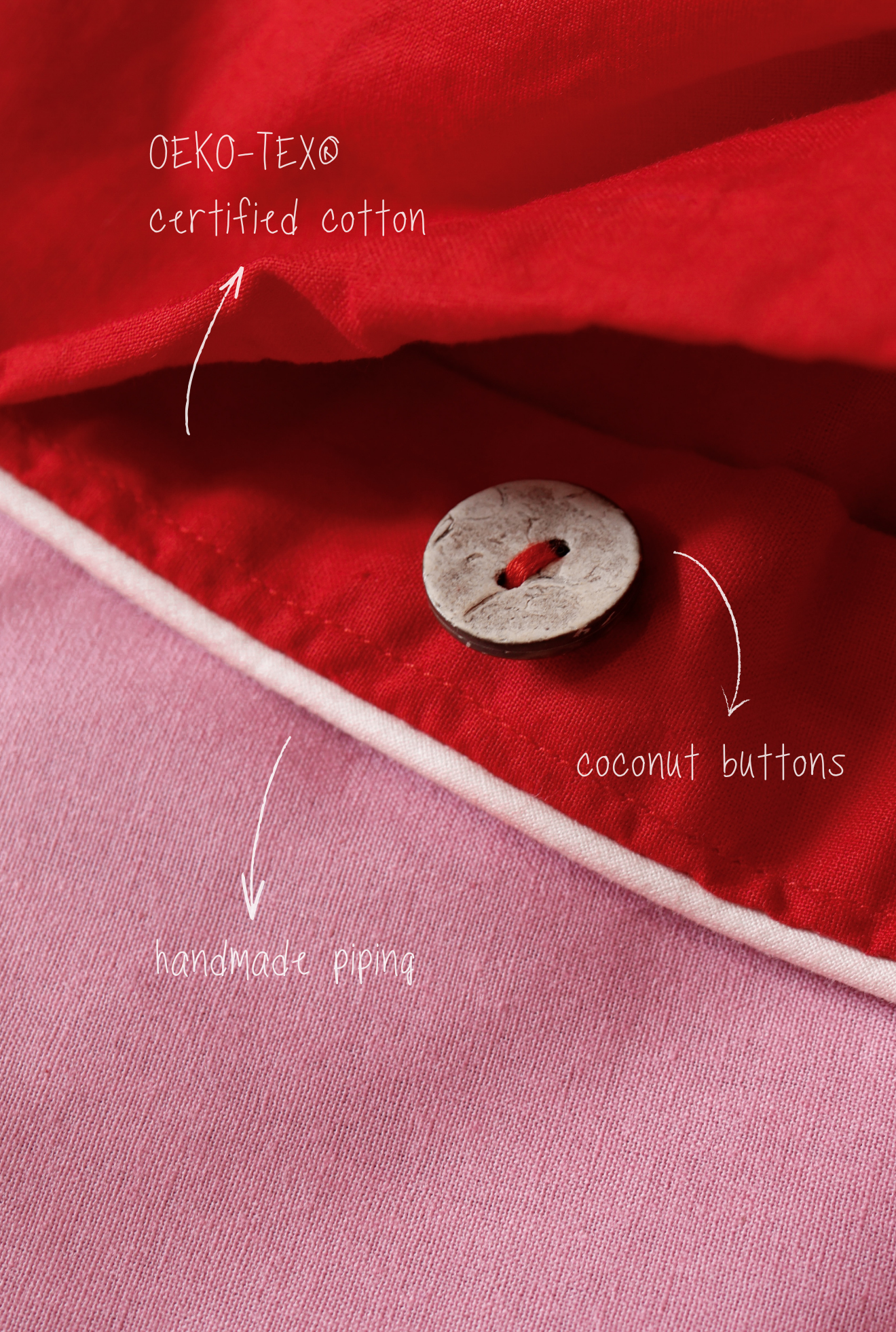 Close-up of a red fabric with a coconut button, labeled 'OEKO-TEX certified cotton' and 'handmade piping'.