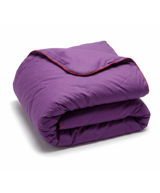 A folded purple quilted comforter with a thin red piping trim along the edge, shown on a clean white background.