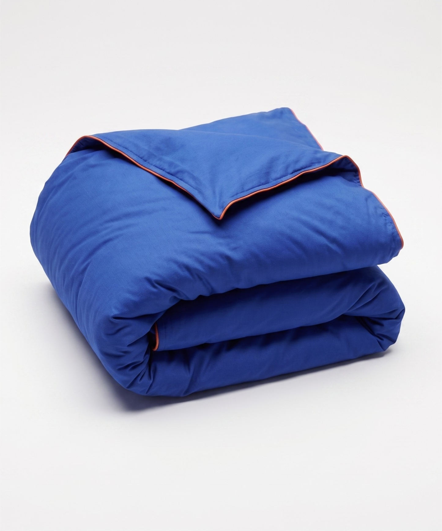 A folded royal blue comforter or duvet with thin orange piping trim along the edges, shown on a clean white studio background.