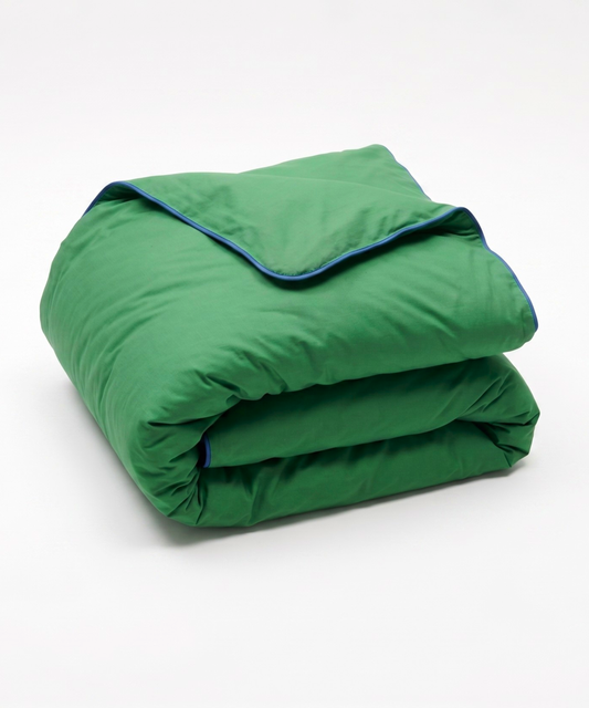 A folded green quilted comforter or duvet with a thin blue piping trim along the edge, shown on a clean white background.
