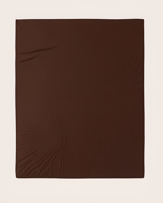 A dark brown fitted sheet laid flat against a light beige background.