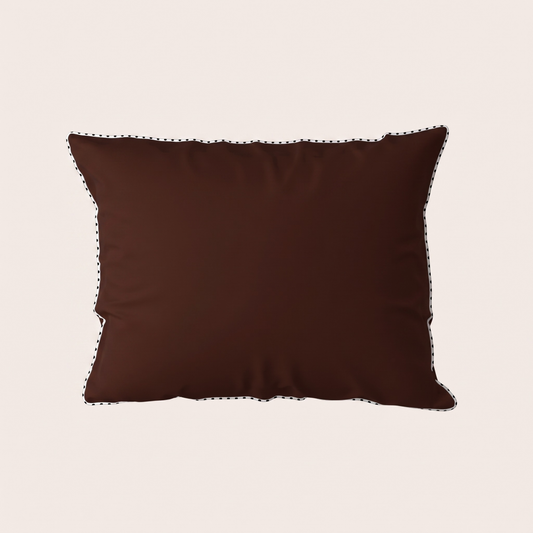 A dark brown rectangular throw pillow with black embroidered trim along the edges, shown against a solid light beige background.