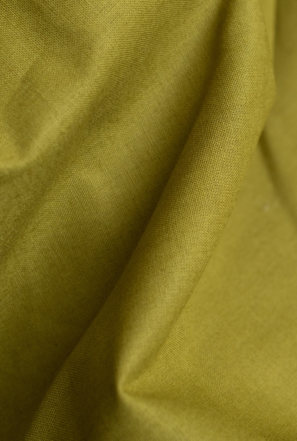 A close-up of draped olive green fabric with visible woven texture and soft folds.