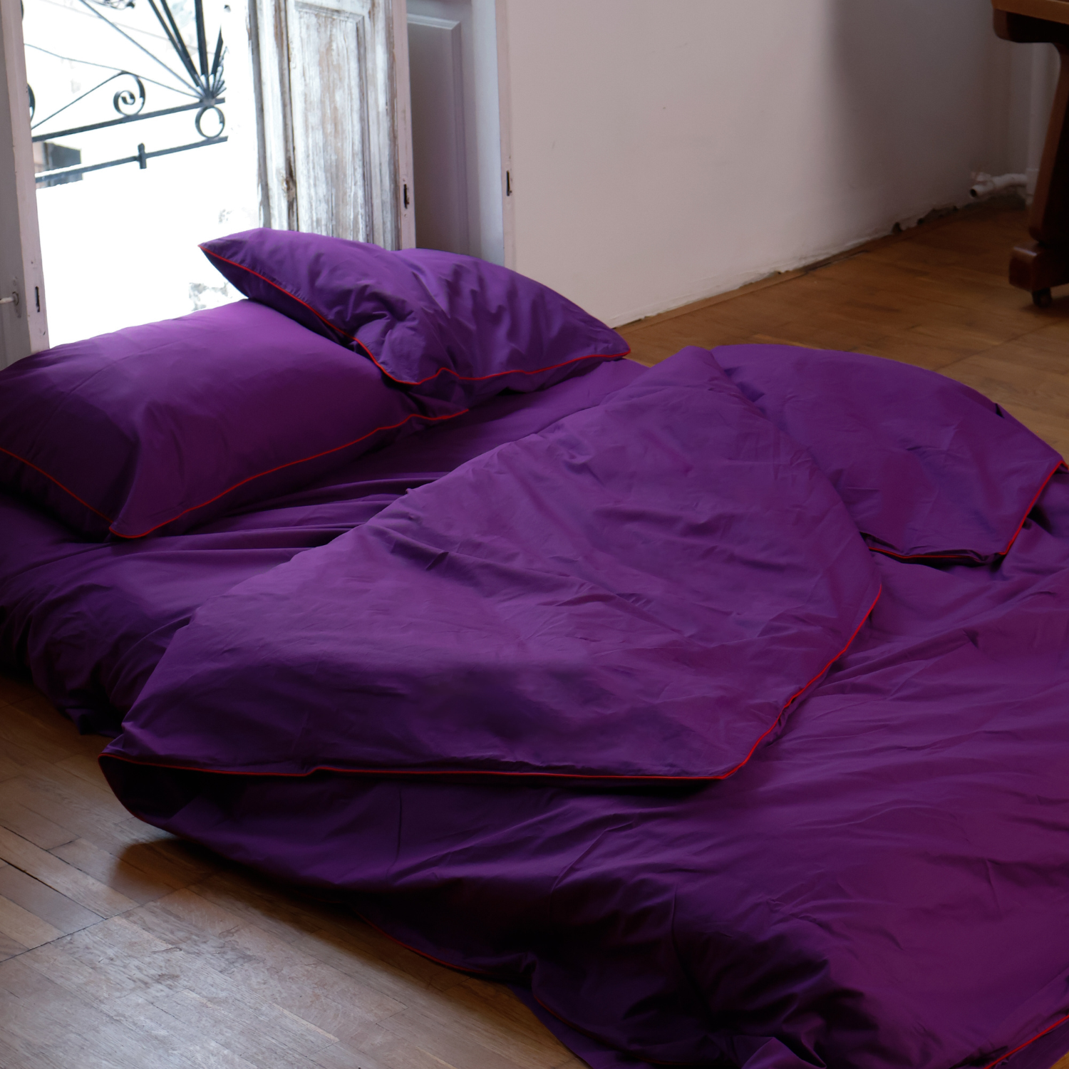 Aesthetic purple bedding by BUTTIA featuring a full set with a red-piped duvet cover and matching pillowcases.
